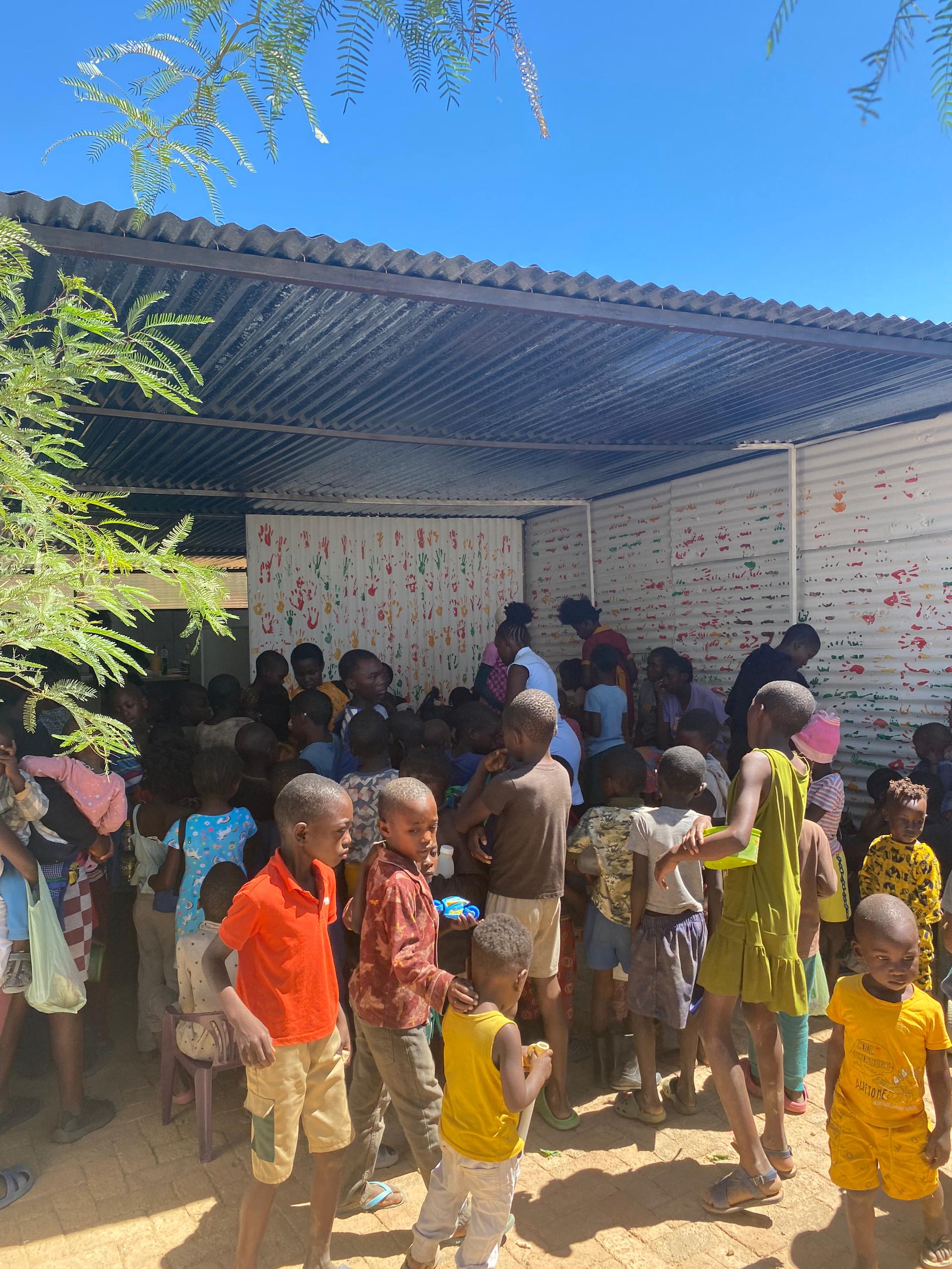 Children gathered outside during outreach